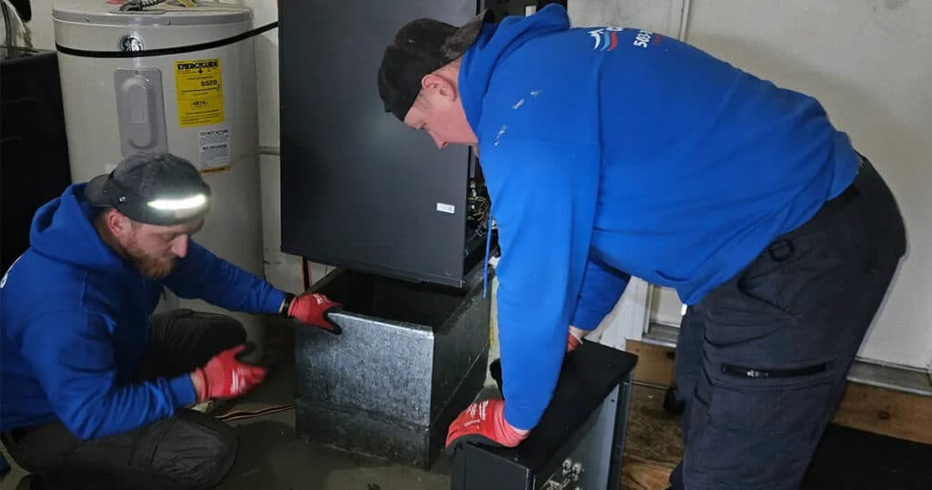 Two Conrad tech working on a furnace
