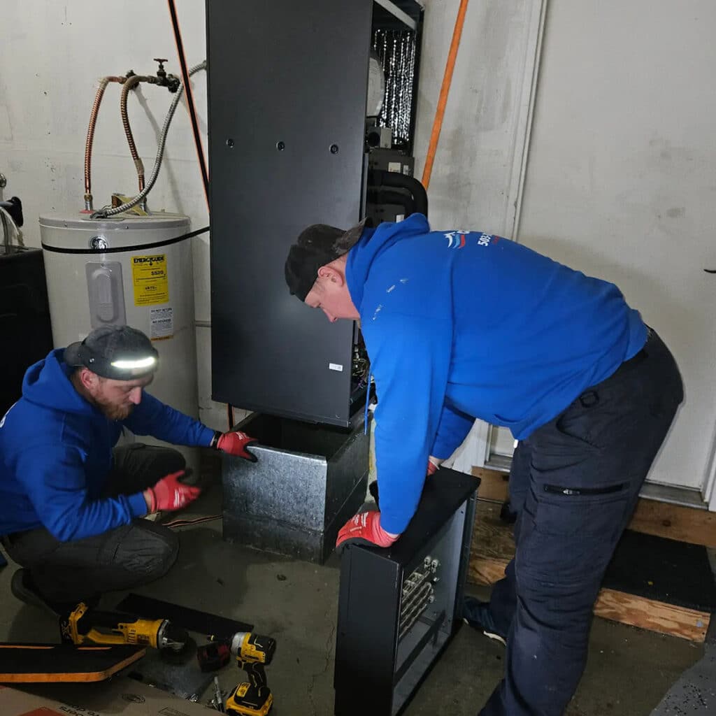 two Conrad techs working on furnace